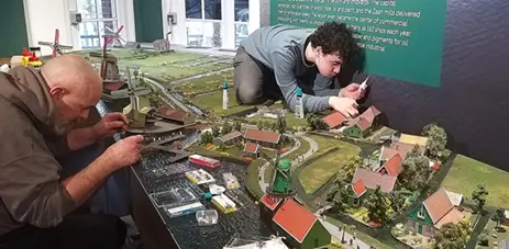 Twee modelbouwers aan het werk aan de Zaanse Schans-maquette