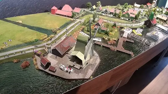 De Zaanse Schans-maquette met houten huizen en een molen aan het water