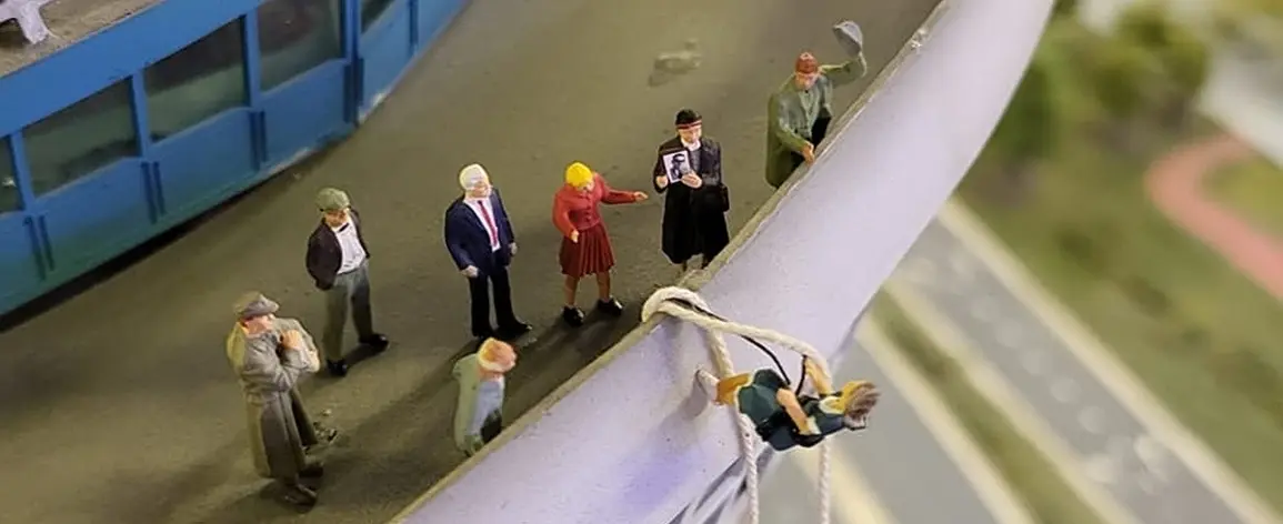De mini-burgemeester over de reling van de Euromast, met toeschouwers
