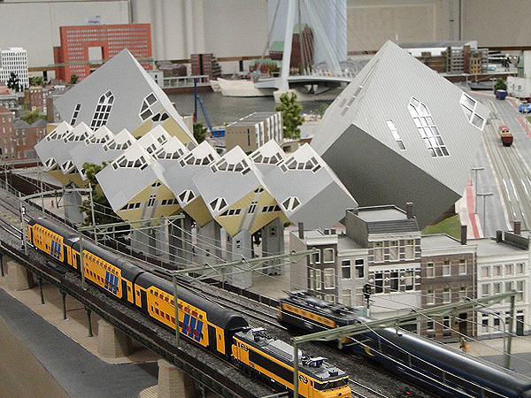 De kubuswoningen in miniatuur. Langs de woningen rijden er een paar treinen.